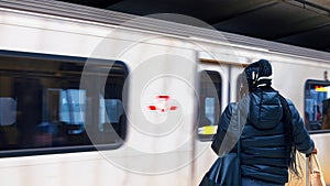 Close-up woman waiting for subway public transport. Subway public transport quickly passes by woman who is standing at