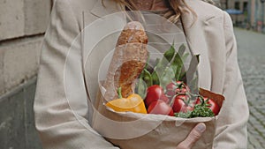 Close up of woman walking on street with grocery bag