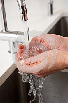 Close Up Of Woman Washing Hands At Kitchen Sink