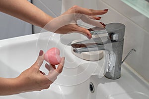close up woman washing hands with soap and water, white foam, in the bathroom, under tap in the sink