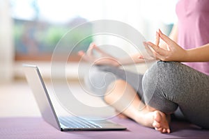 Close up of a woman watching yoga tutorial on laptop photo