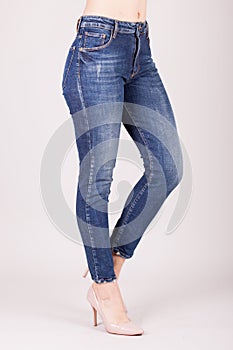 Close up of woman wearing blue jeans. Fit female in blue jeans