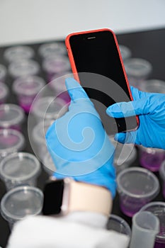 Close Up Of Woman Wearing Lab Coat Using Cellphone In Laboratory