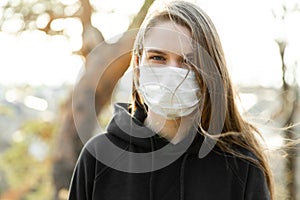 Close up of woman wearing protective face mask outdoor. Coronavirus covid-19 outbreak prevention concept.