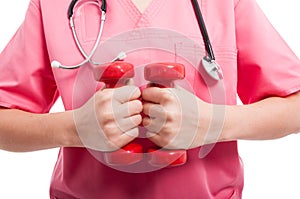 Close-up of woman wearing scrubs training with weights