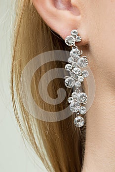 Close up of woman wearing shiny diamond earrings