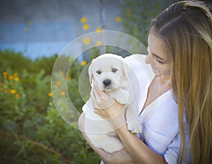 Close up of woman in white blouse with puppy of labrador