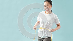 Close up woman in white shirt measuring her waist with yellow measuring tape