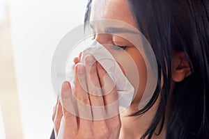 Close up of woman with wipe blowing nose or crying