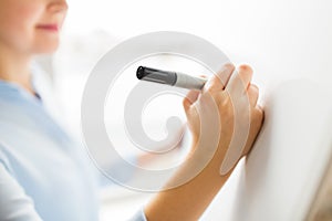Close up of woman writing something on white board