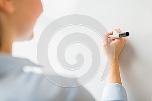 Close up of woman writing something on white board