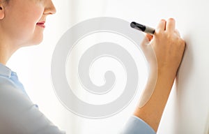 Close up of woman writing something on white board