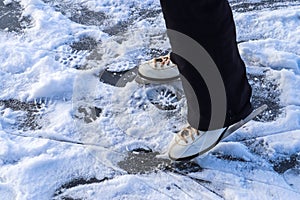 Close up on womans feet wearing ice skating boots and standing on ice