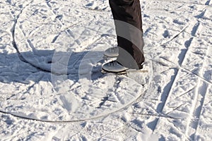 Close up on womans feet wearing ice skating boots and standing on ice