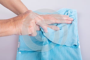 Close-up of womans hands folding a t-shirt.