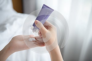 Close up of women applying body lotion cream on hand