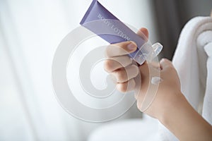 Close up of women applying body lotion cream on hand