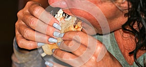 Close up of a women eating a taco using two hands