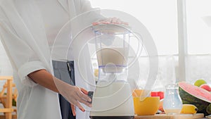 Close up women hand are making fruit yogurt smoothie in kitchen