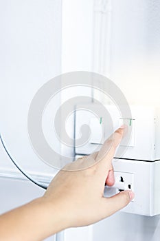 Close up women hand turn on off on light switch.