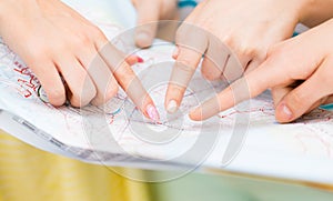 Close up of women hands pointing finger to map