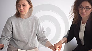 Close up women holding each others hands during group therapy, psychotherapy concept. Womens support circle
