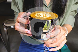 Close-up of women holding a hot latte coffee