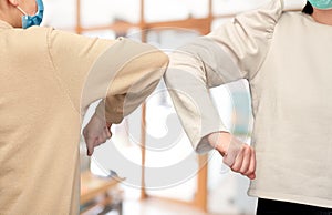 close up of women making elbow bump gesture