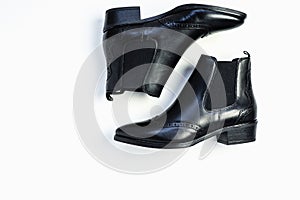 Close up of women`s black leather chelsea boots on white background with reflection. Women`s footwear for city, urban