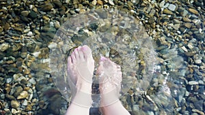 close-up of a women's feet threading in cold water, making a splash