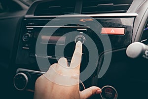 Close-up Of Women`s Hand Turning Button Of Radio In Car.