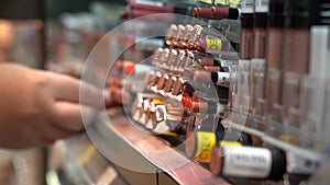 Close-up of women's hands choosing lipstick in a cosmetics store