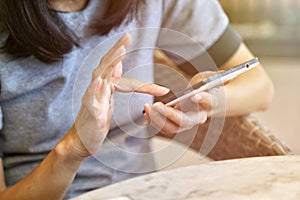 Close up of women`s hands holding cell telephone and browse mobile screen with her index finger. photo