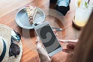 Close up of women`s hands holding mobile phone in cafe