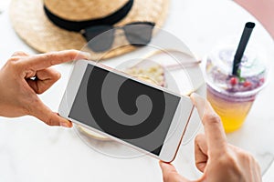 Close up of women`s hands take a photo of cheese cake and drinks in cafe