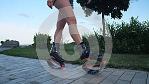 Close-up of women`s legs in angoo jumps shoes. A woman goes down the street. 4K Slow Mo
