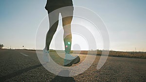 Close up of women's legs running on asphalt road. Slow motion video. Sport concept.