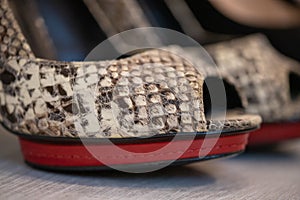 A close up of a women's shoe, snake leather peep toe pumps