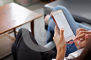 Close-up women use smart phone  white screen on sofa in hre home photo