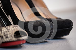 A close up of a womens shoe, snake leather peep toe and black suede pumps