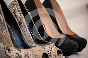 A close up of a womens shoe, snake leather peep toe pumps