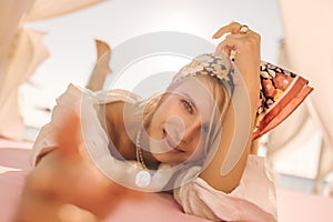 Close-up of wonderful young woman lies on beach under burning sun.