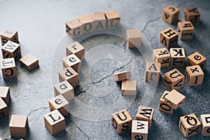 Close up of wood cube letter word of Leader and GOAL. Idea of motivation and inspiration in business success and corporate