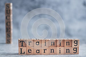 Close up of wood cube letter word of Training and learning with SUCCESS. Idea of motivation and inspiration in business vision and