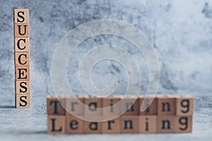 Close up of wood cube letter word of Training and learning with SUCCESS. Idea of motivation and inspiration in business vision and