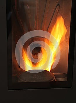 Close-up of wood pellet stove firebox in living room for eco-friendly heating