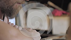 Close-up. a woodcarver processes a walnut wood board with a chisel. craftsman makes a tea tray