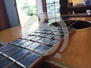 Close-up of wooden acoustic guitar strings on the table.