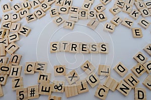 close-up wooden alphabet blocks on white background, word stress, concept transient negative emotional state, nervous system