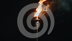 Close up wooden burning torch on black background, light of fire flames and sparkles
